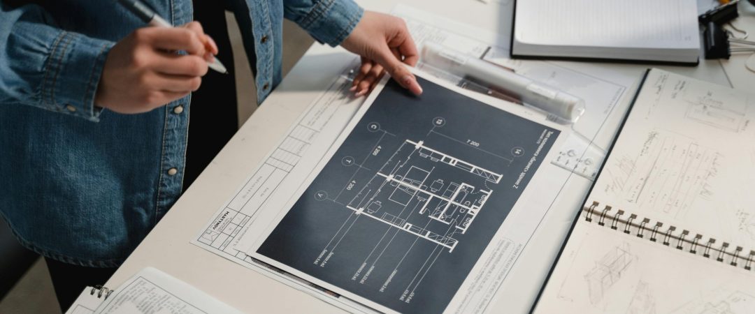 Engineer reviewing architectural blueprints on a desk with technical drawings.